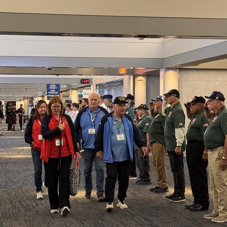 Veterans and guardians walk through the homecoming salute.