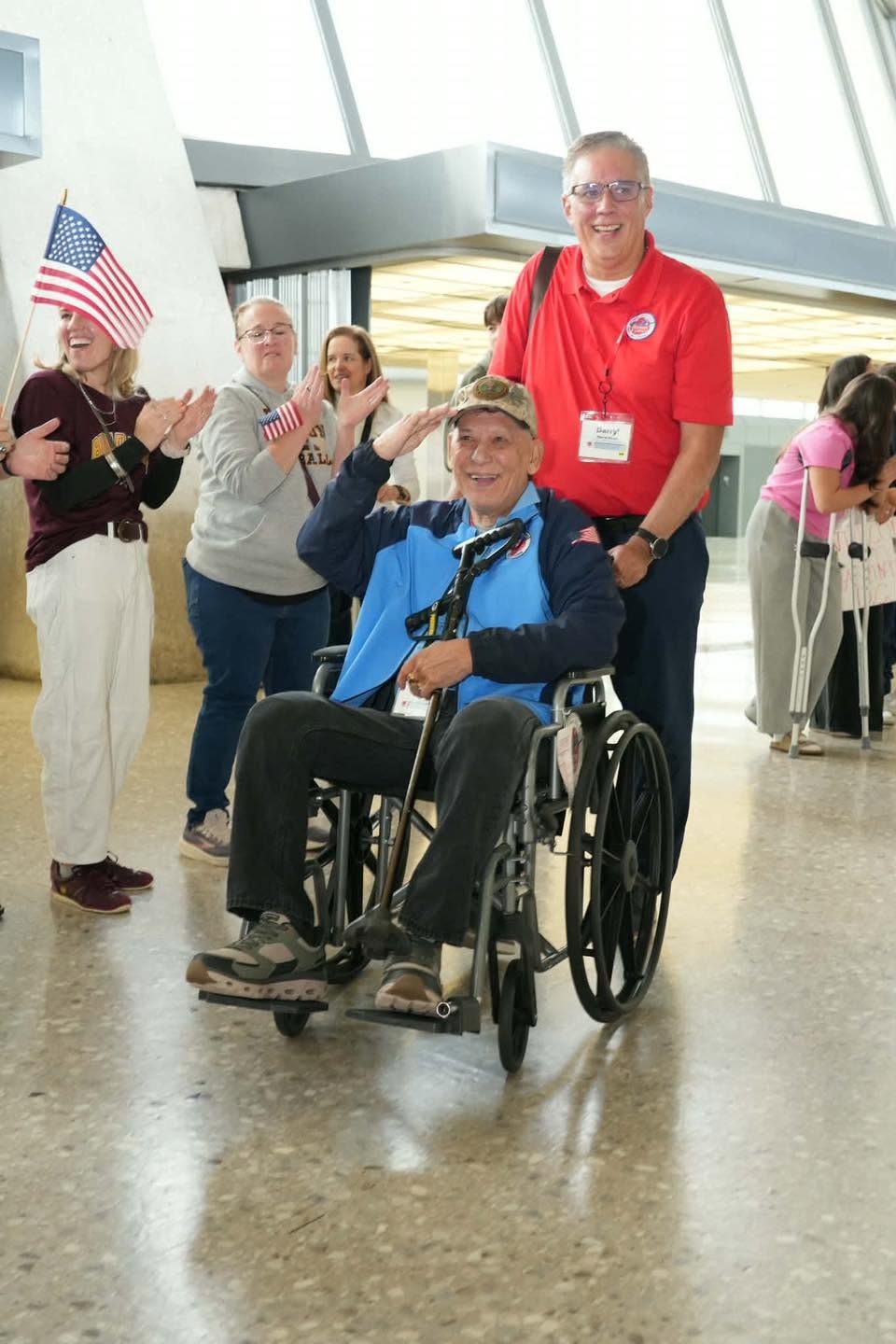 A veteran and guardian greeted by supporters at Dulles.